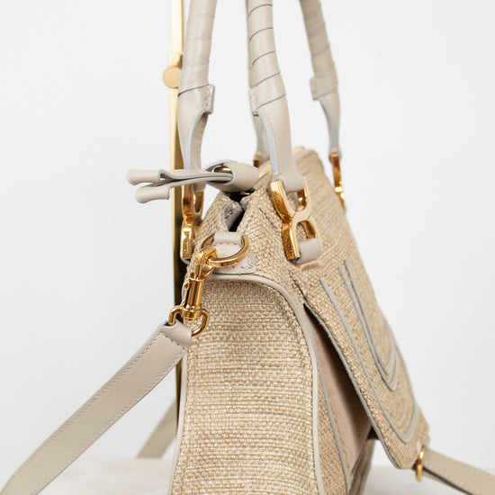 Beige handbag with straw texture and gold accents on a white background