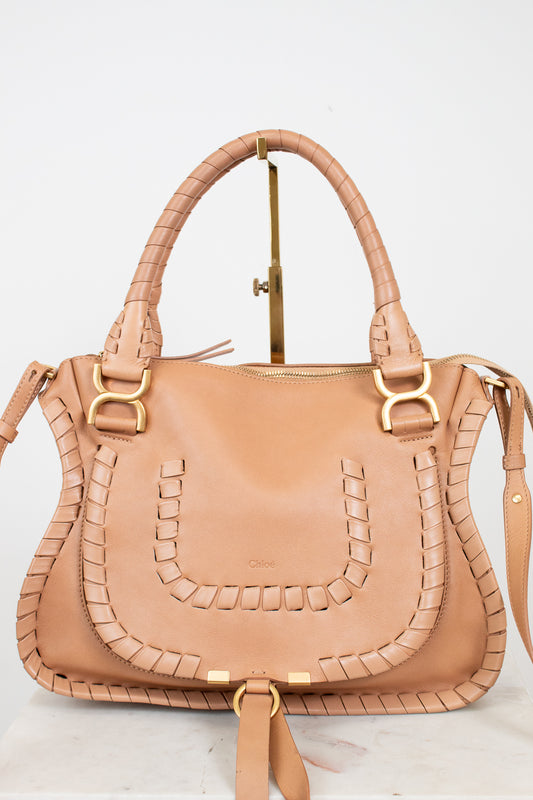 Tan handbag with gold accents on a light gray background