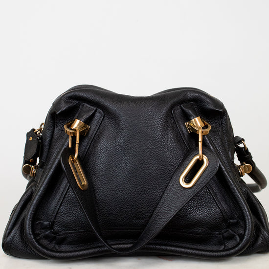 Black handbag with gold hardware on a white background