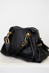 Black handbag with gold hardware on a white background