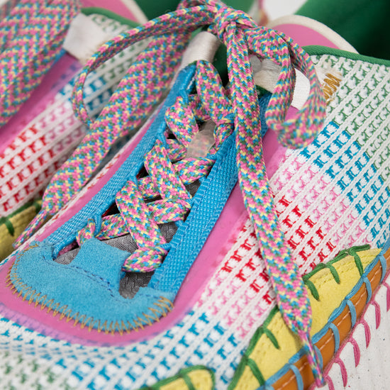 Colorful woven sneakers with patterned laces on a white background