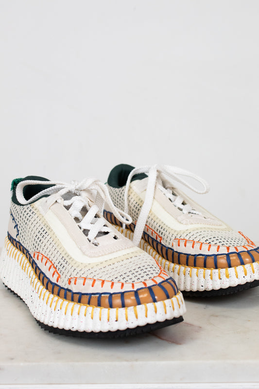 Pair of white sneakers with colorful accents on a light gray background