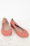 A pair of dusty pink leather ballet flats with scalloped edges, displayed on a light marble surface against a white background.