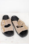 Beige sandals with gold buckles on a white background