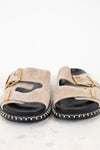 Pair of beige sandals with gold buckles on a white background