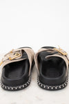 Pair of black and beige shoes with gold accents on a white background