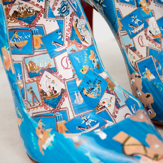 Blue high-heeled shoes with colorful patterned design on a light background