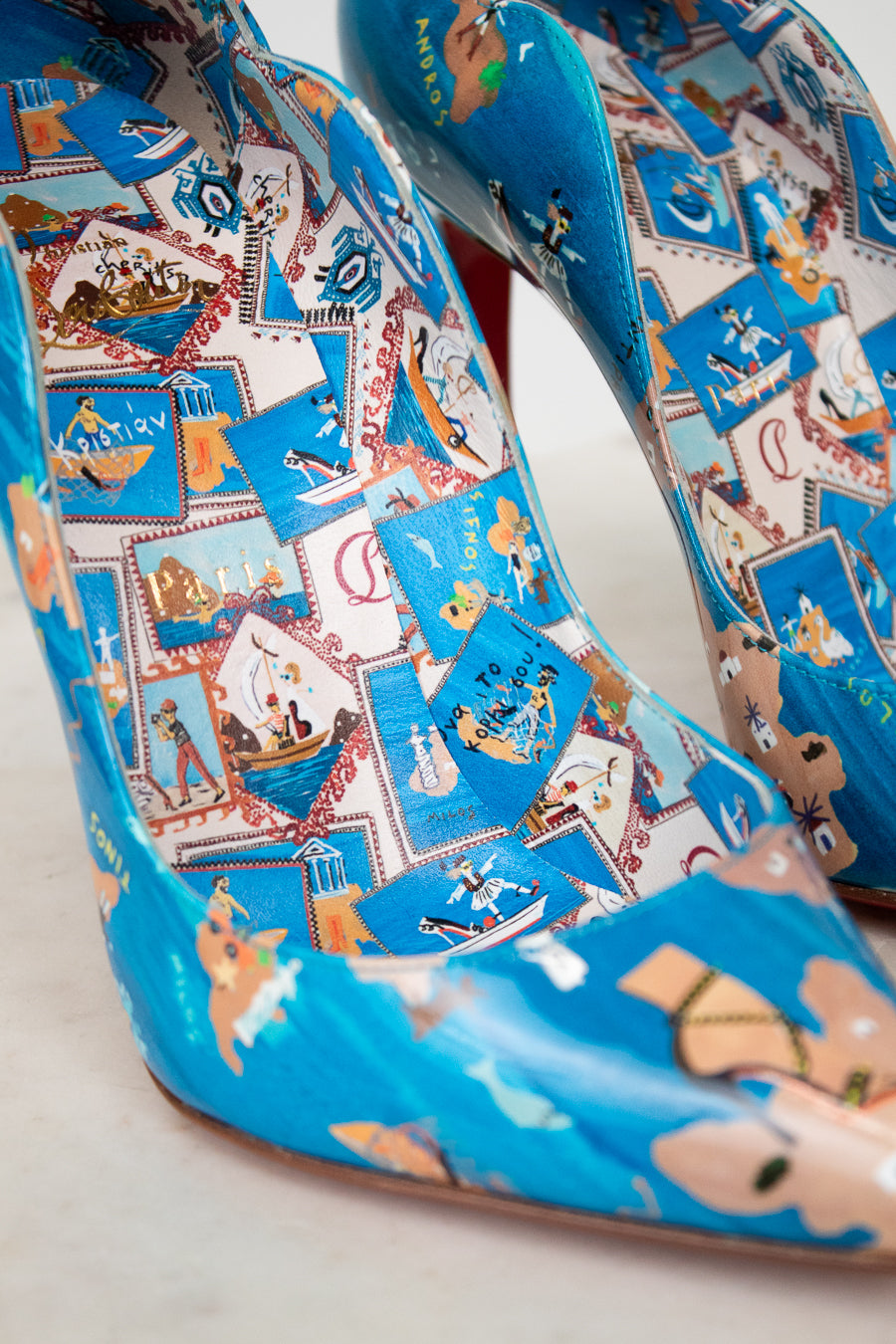 Blue high-heeled shoes with colorful patterned design on a light background