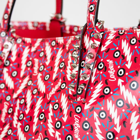 Red handbag with a colorful pattern and 'Louboutin' branding.