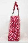 Red patterned handbag with silver studs on a white background