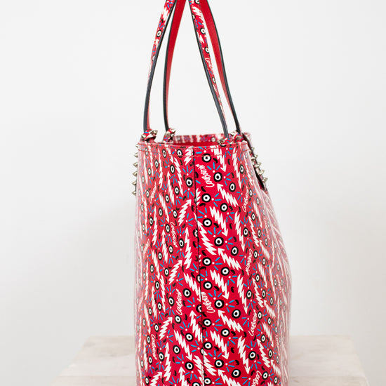 Red patterned handbag on a white surface with a white background