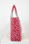 Red patterned handbag on a white surface with a white background