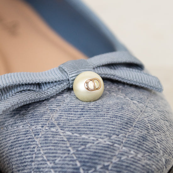 Blue shoe with a button detail on a light background
