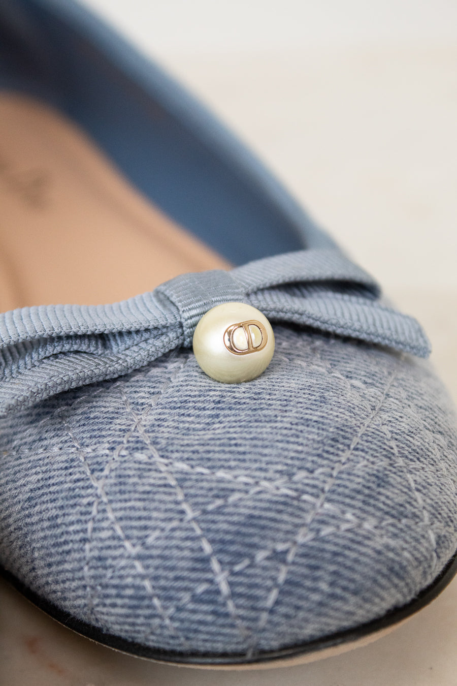 Blue shoe with a button detail on a light background