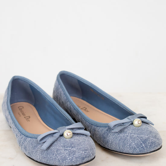Pair of blue shoes with bow details on a white background