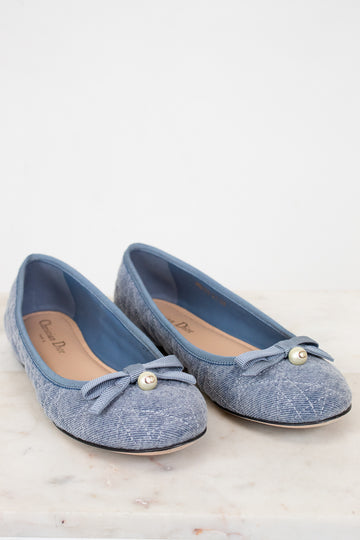 Pair of blue shoes with bow details on a white background