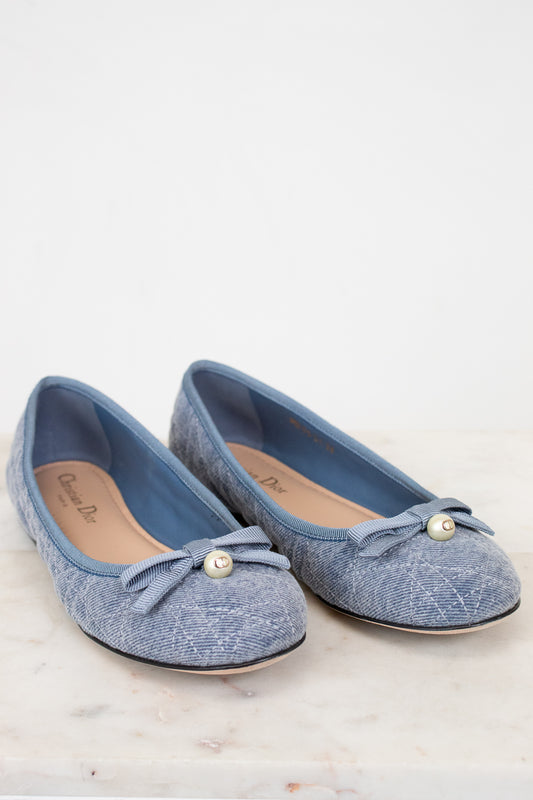 Pair of blue shoes with bow details on a white background