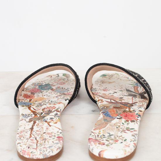 Another view of floral sandals on a marble surface and white background