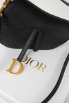 Close-up of black 'Christian Dior' saddle bag on white 'DIOR' box