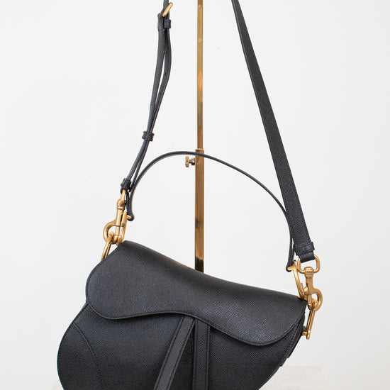 Black saddle bag with gold 'D' logo and hardware with black straps