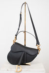 Black saddle bag with gold 'D' logo and hardware with black straps
