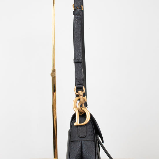 Side view of black bag on gold stand with visible logo