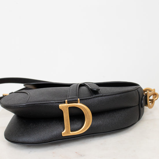 Bottom view of black bag with gold 'D' logo 
