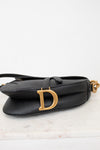 Bottom view of black bag with gold 'D' logo 