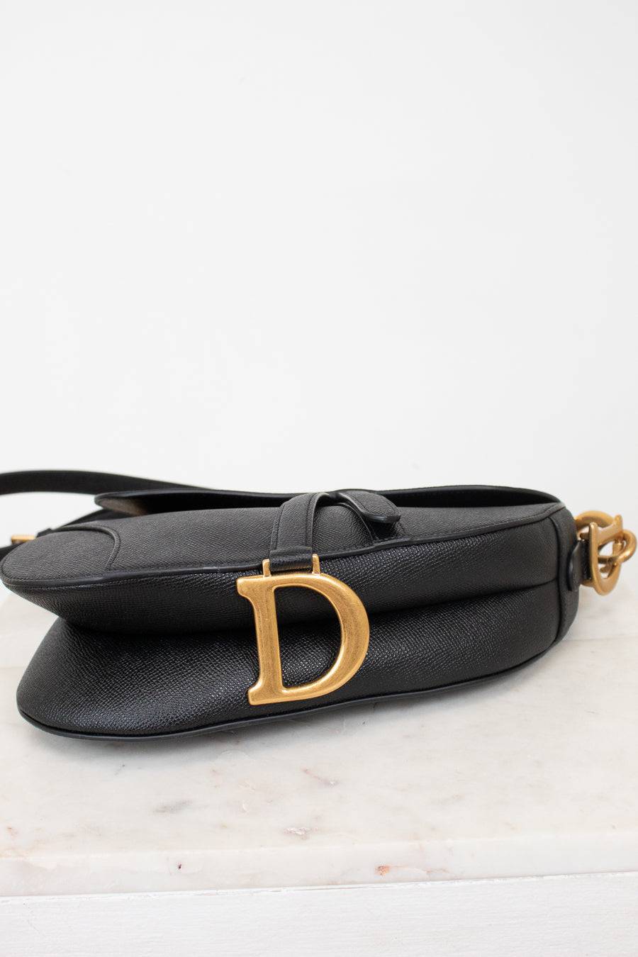 Bottom view of black bag with gold 'D' logo 