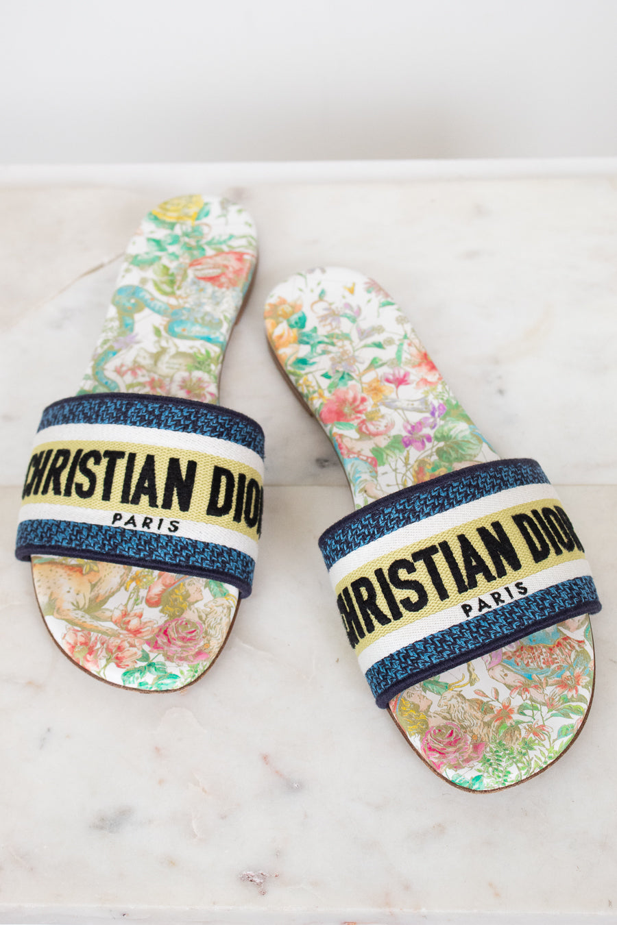 Floral sandals with 'Christian Dior' strap on a marble surface
