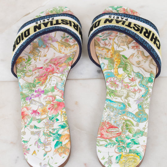Floral sandals with 'Christian Dior' blue/black/white/chartreuse strap on a marble surface