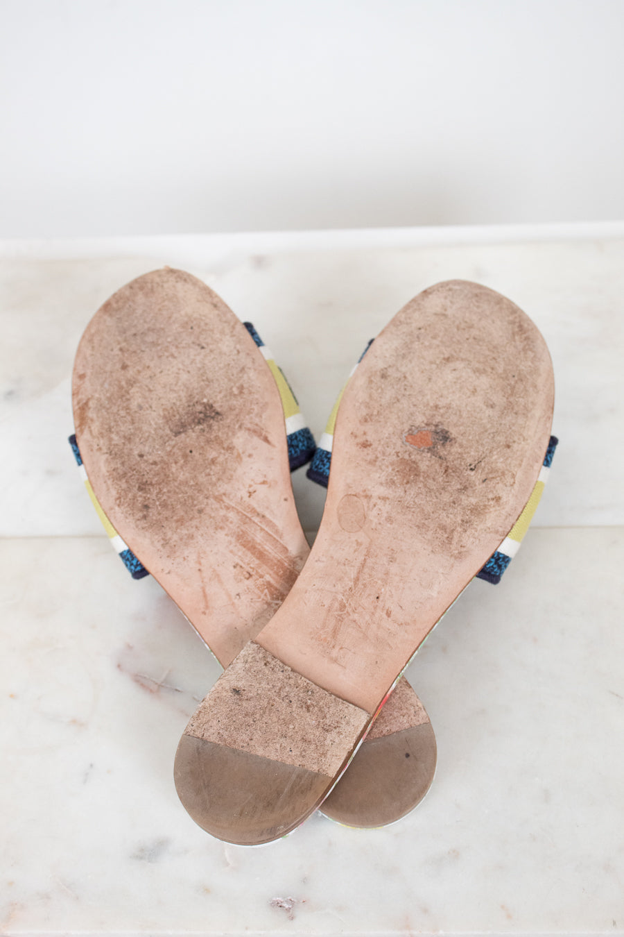 Bottom view of flat sandal soles with white and marble background