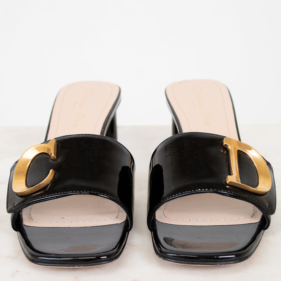 Black high-heeled shoes with gold accents on a white background