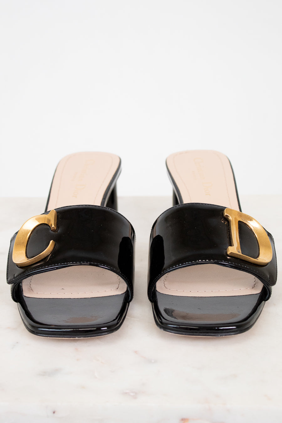 Black high-heeled shoes with gold accents on a white background