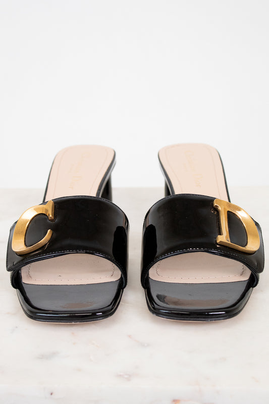 Black high-heeled shoes with gold accents on a white background