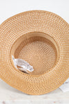 Woven straw hat with a visible brand label on a white background
