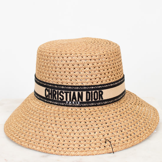 Beige straw hat with Christian Dior band on a white background