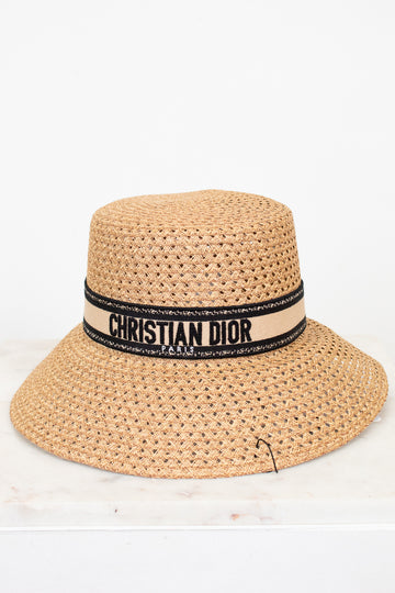 Beige straw hat with Christian Dior band on a white background