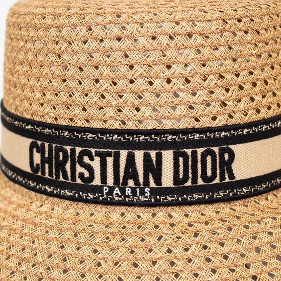 Woven straw hat with a Christian Dior band on a white background