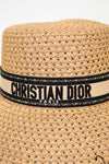 Woven straw hat with a Christian Dior band on a white background