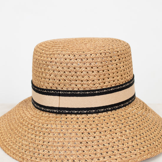 Beige straw hat with a black band on a white background