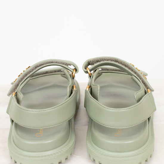 Pair of green sandals with straps on a white background