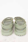 Pair of green sandals with straps on a white background