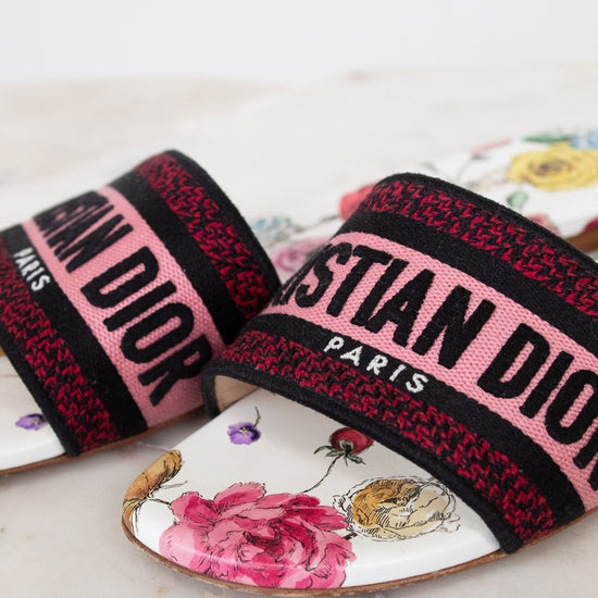 Floral flat sandals with Christian Dior in pink and black woven into toe strap on marble background