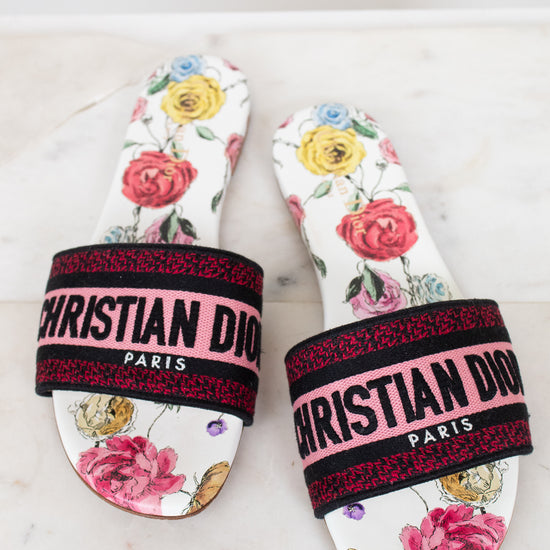 Floral flat sandals with Christian Dior in pink and black woven into toe strap on marble background