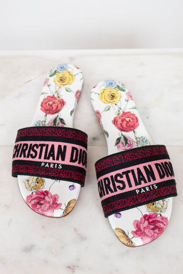 Floral flat sandals with Christian Dior in pink and black woven into toe strap on marble background