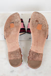 Bottom view of flat sandals with white marble background