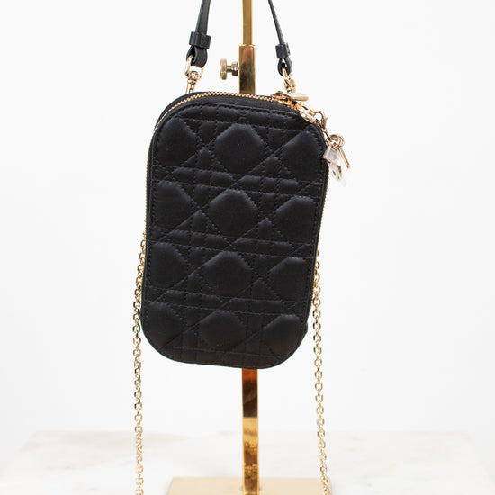 Black quilted pouch case with gold chain on a white background