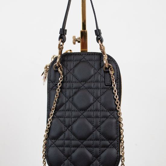 Black quilted handbag with gold chain strap on a white background