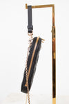 Black handbag with gold zipper and chain detail on a white background